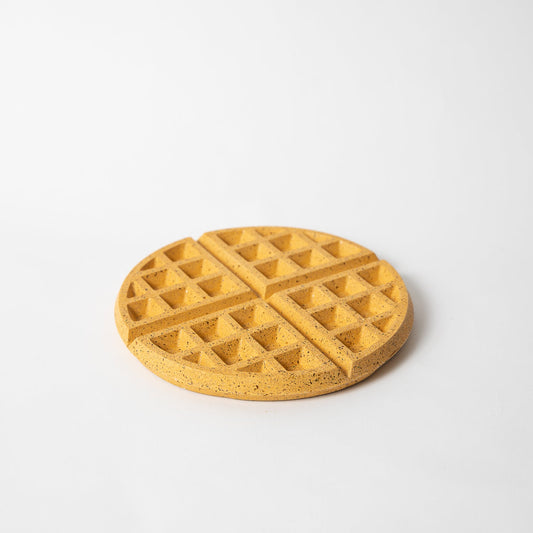 Round marigold terrazzo waffle trivet with diamond-grid pattern, flat top surface