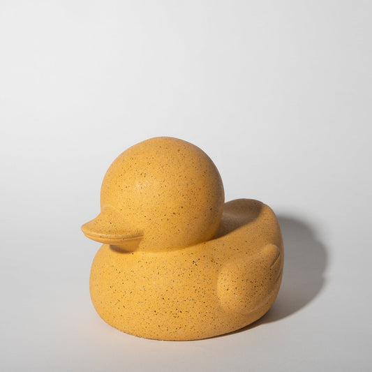 Marigold rubber duck sculpture with rounded beak and head, speckled texture