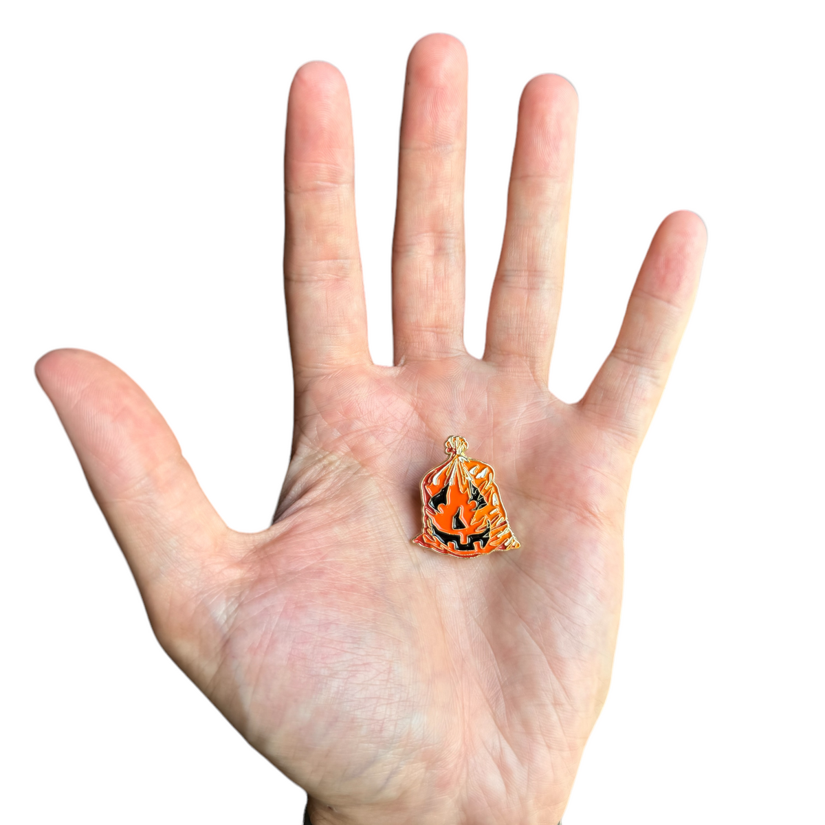 Enamel jack-o'-lantern leaf bag pin, orange pumpkin with black cutout and gold border