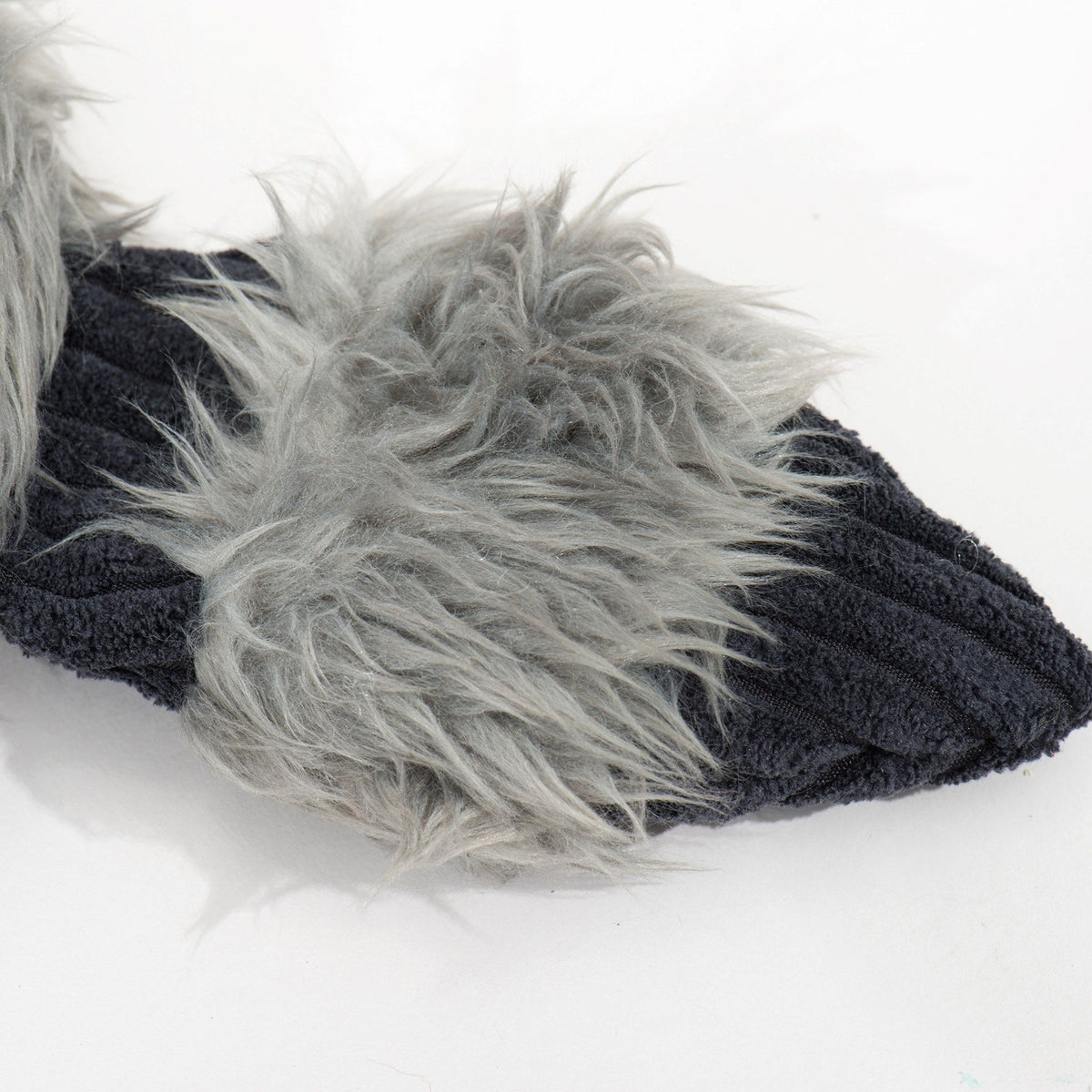 Close-up of gray faux fur and black ribbed fabric on the raccoon dog toy