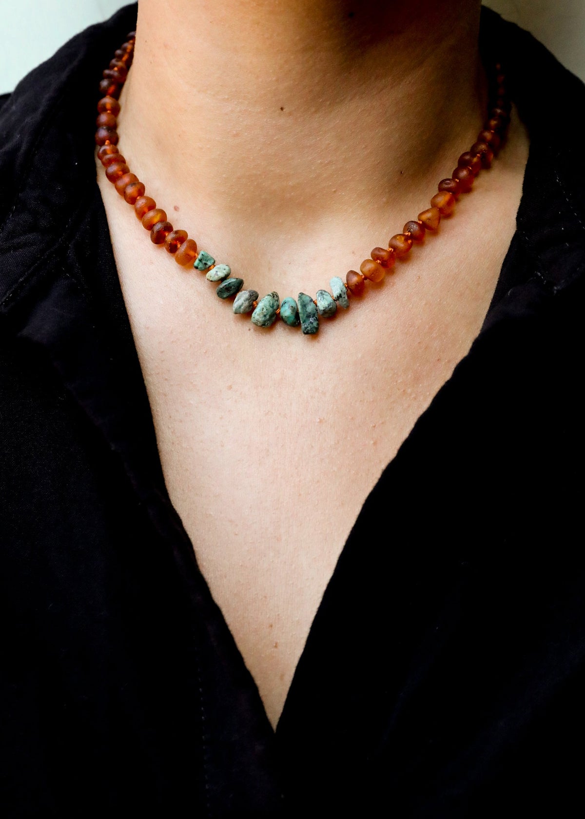 Cognac amber bead necklace worn, turquoise jasper teardrop stones at center