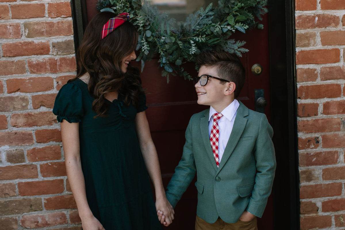 Red plaid neck tie with white shirt collar on a formal boys outfit