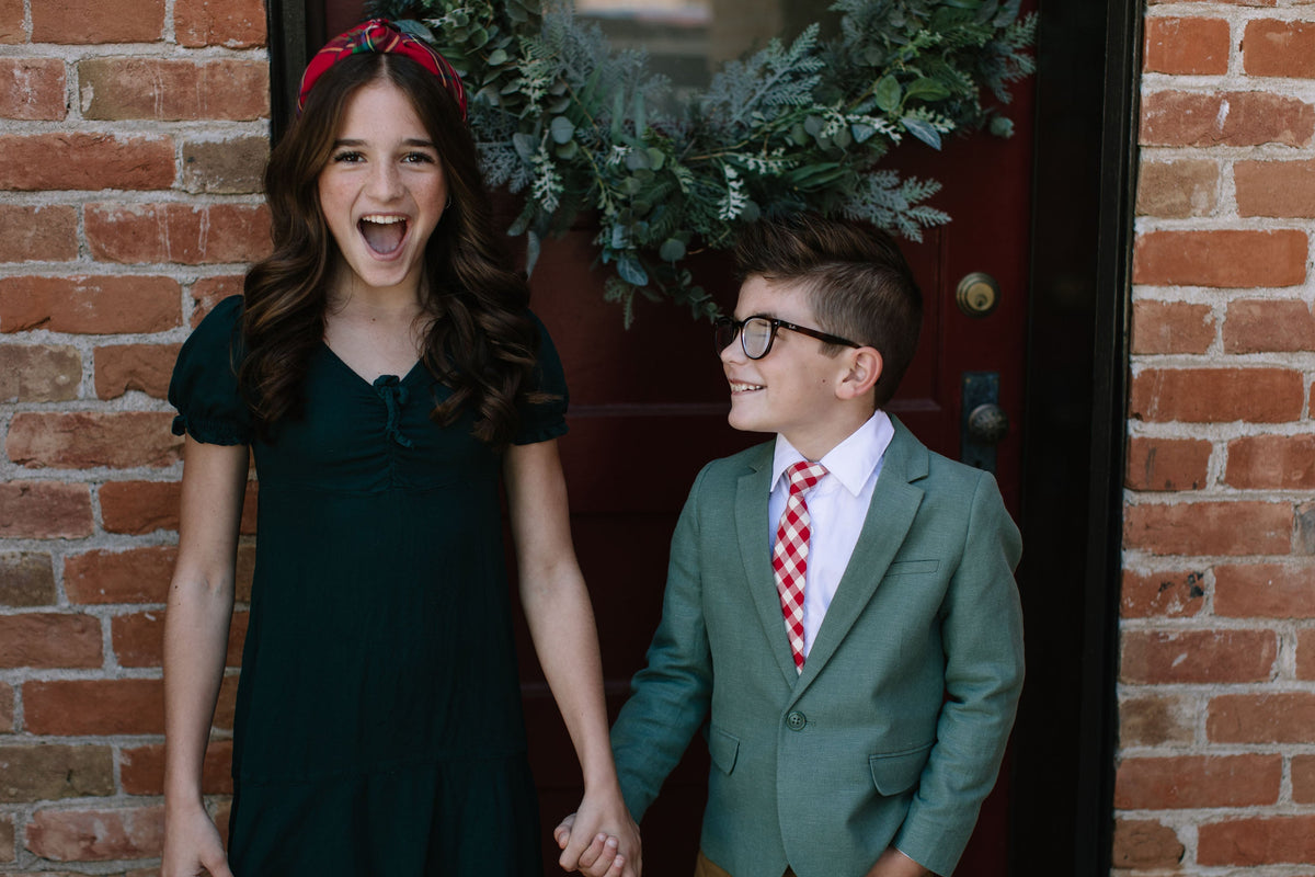 Boys red plaid neck tie with white shirt and glasses, front view