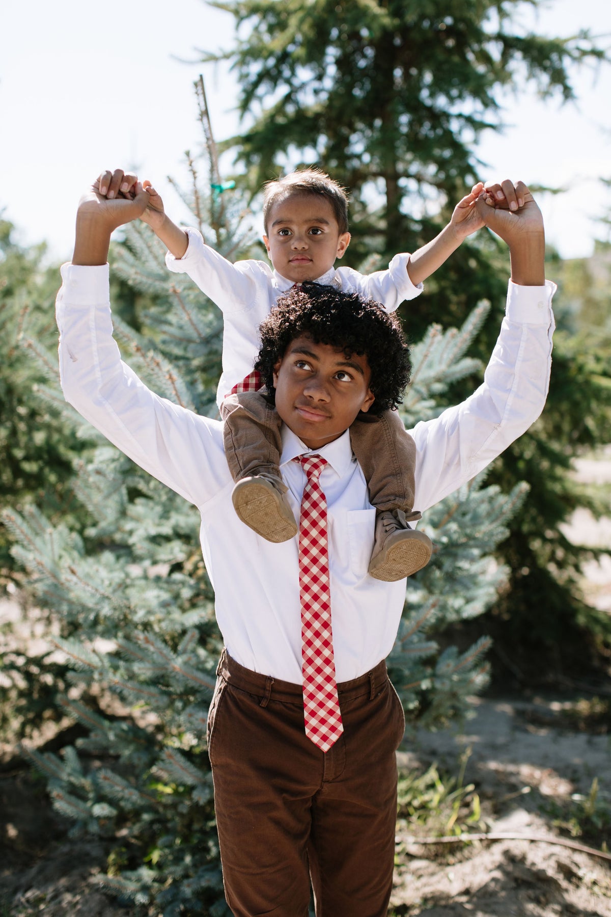 Boys red plaid neck tie centered on white shirt, full-body