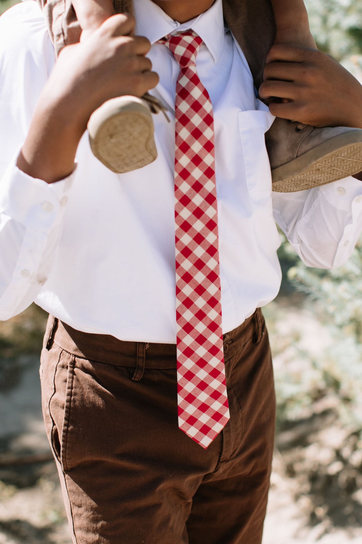Boys red plaid neck tie with white shirt collar, worn at the front