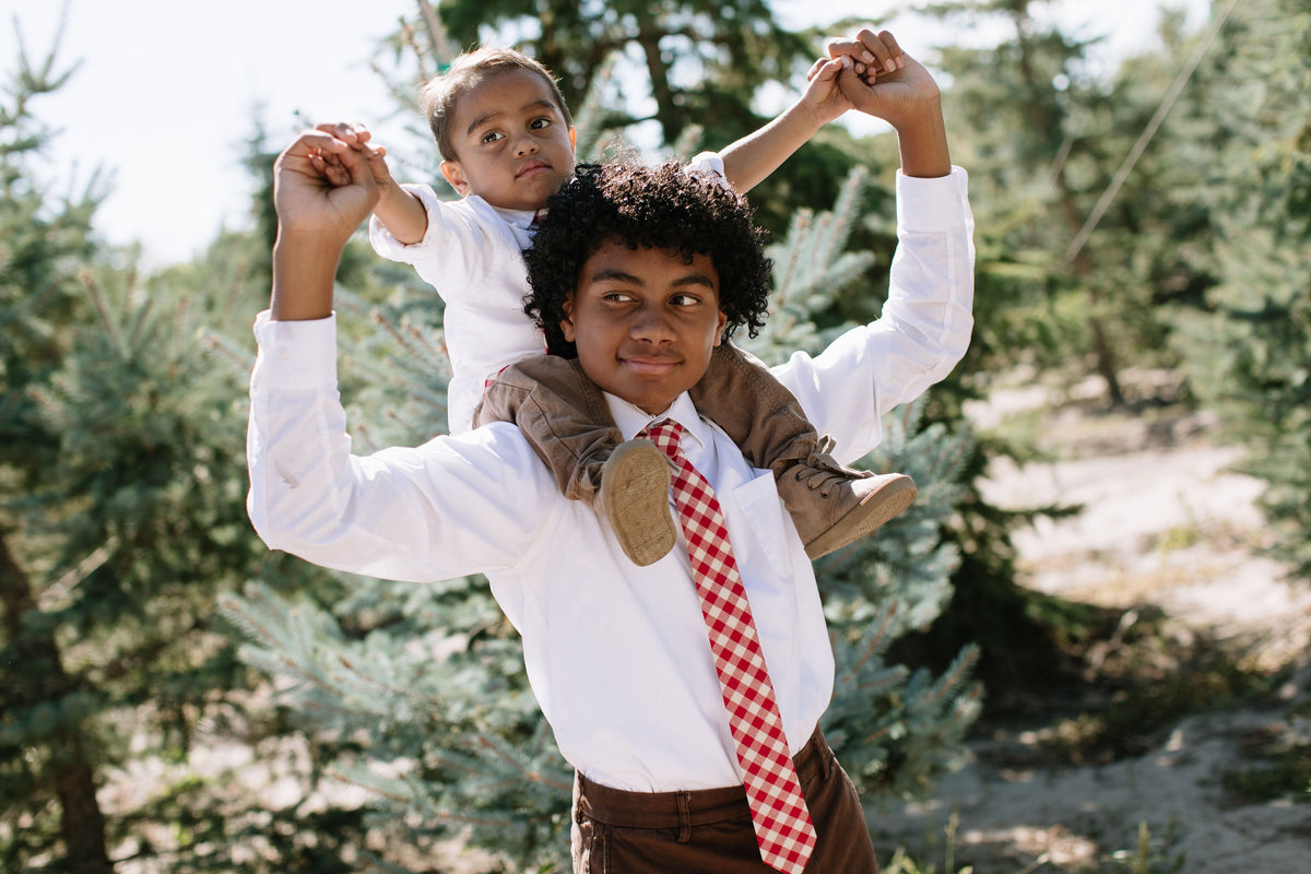 Boys red plaid neck tie on white shirt, outdoors