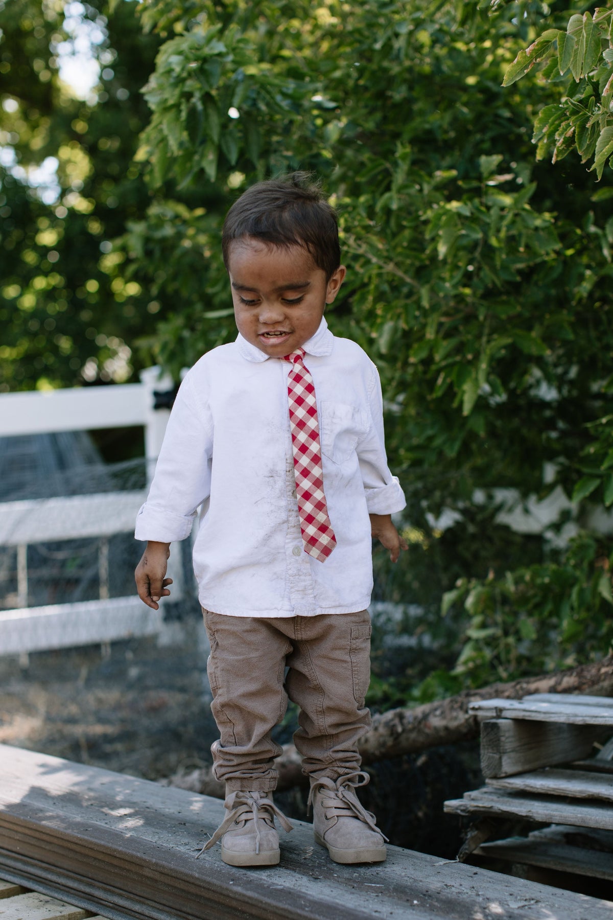 Boys red plaid neck tie with white shirt, side view