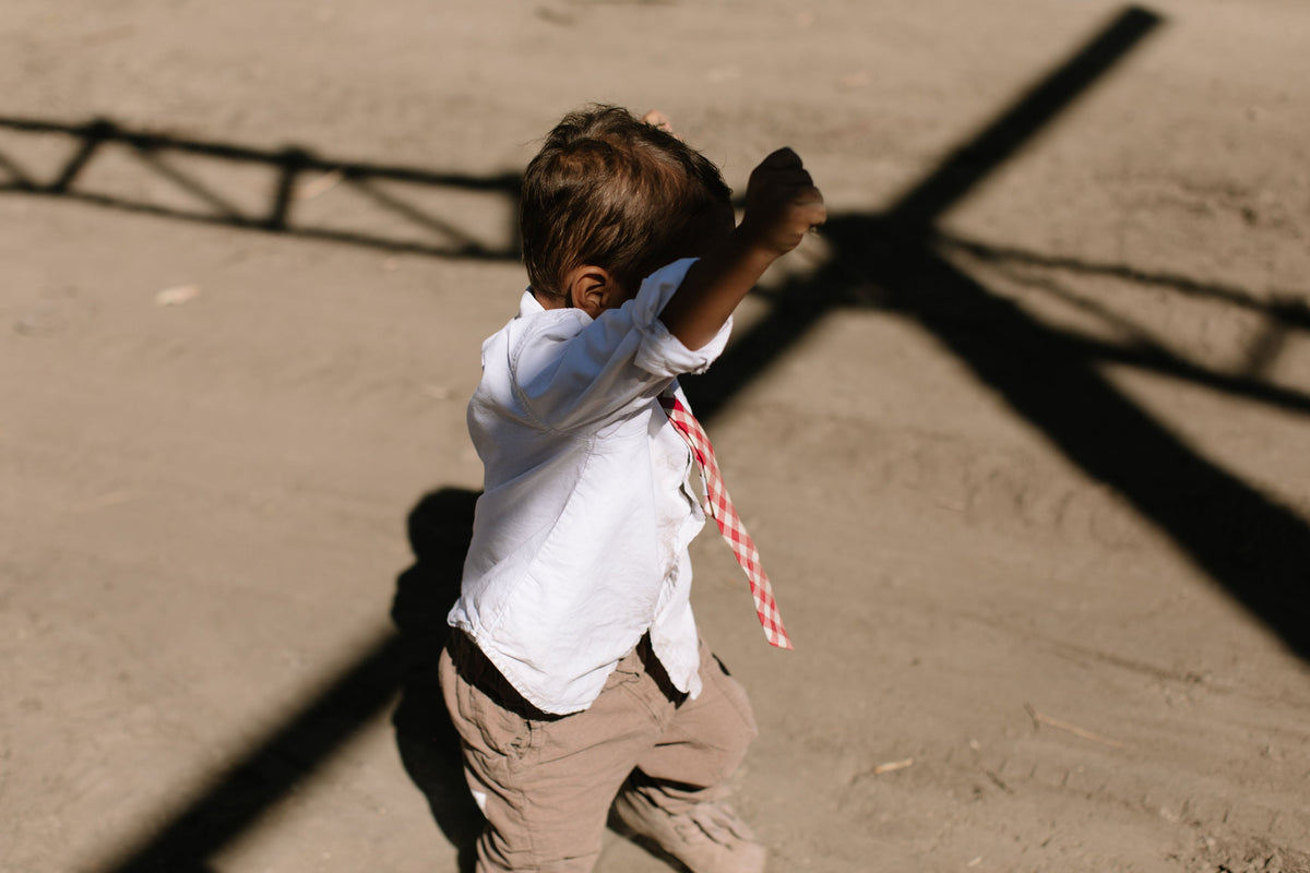 Red and white plaid necktie on a boys shirt, side view