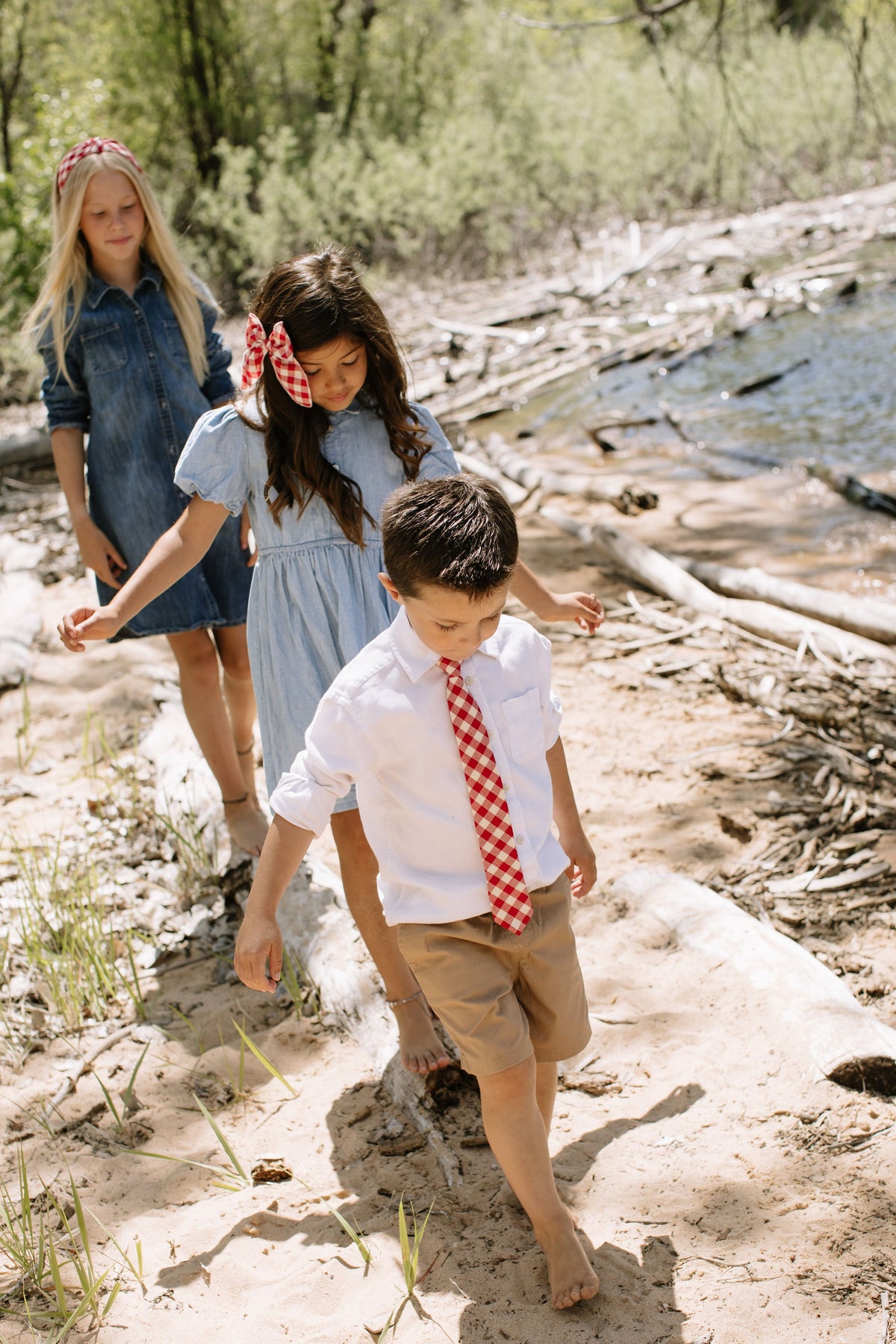 Red and white plaid boys necktie on a white shirt, walking outdoor view