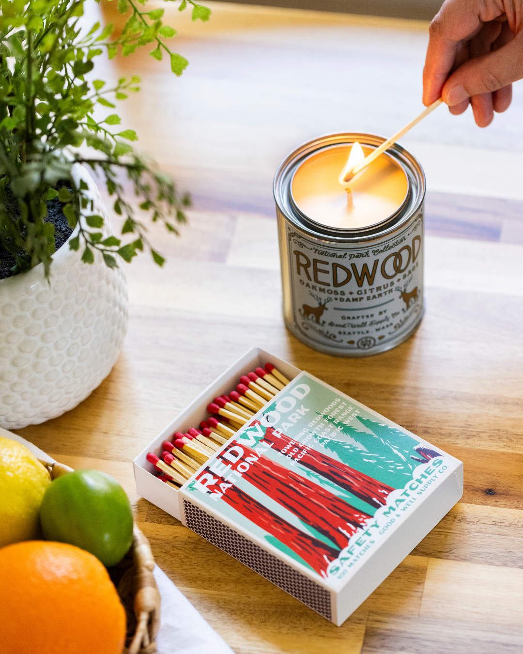 Hand lighting a Redwood-labeled safety match from an open match box