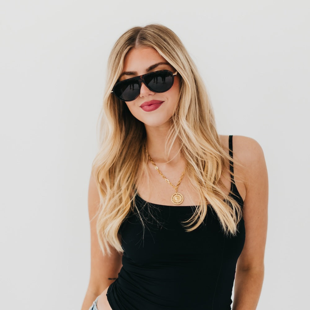 Oval sunglasses with black flat frame and dark lenses