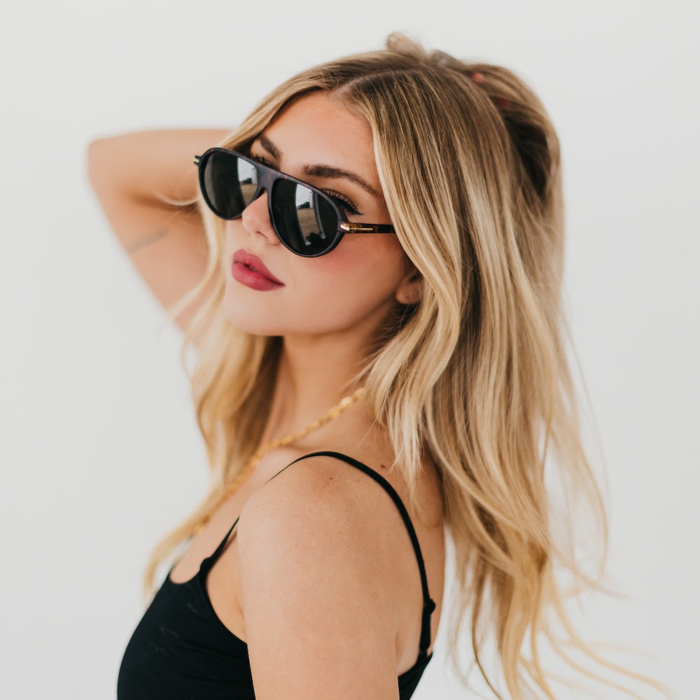 Oval sunglasses with dark tortoise frame and dark lenses