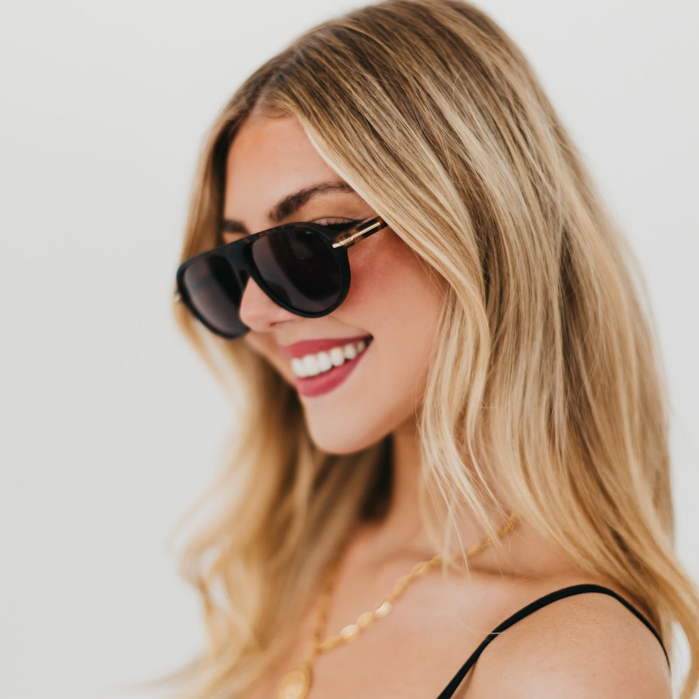 Oval sunglasses with black frame and dark lenses