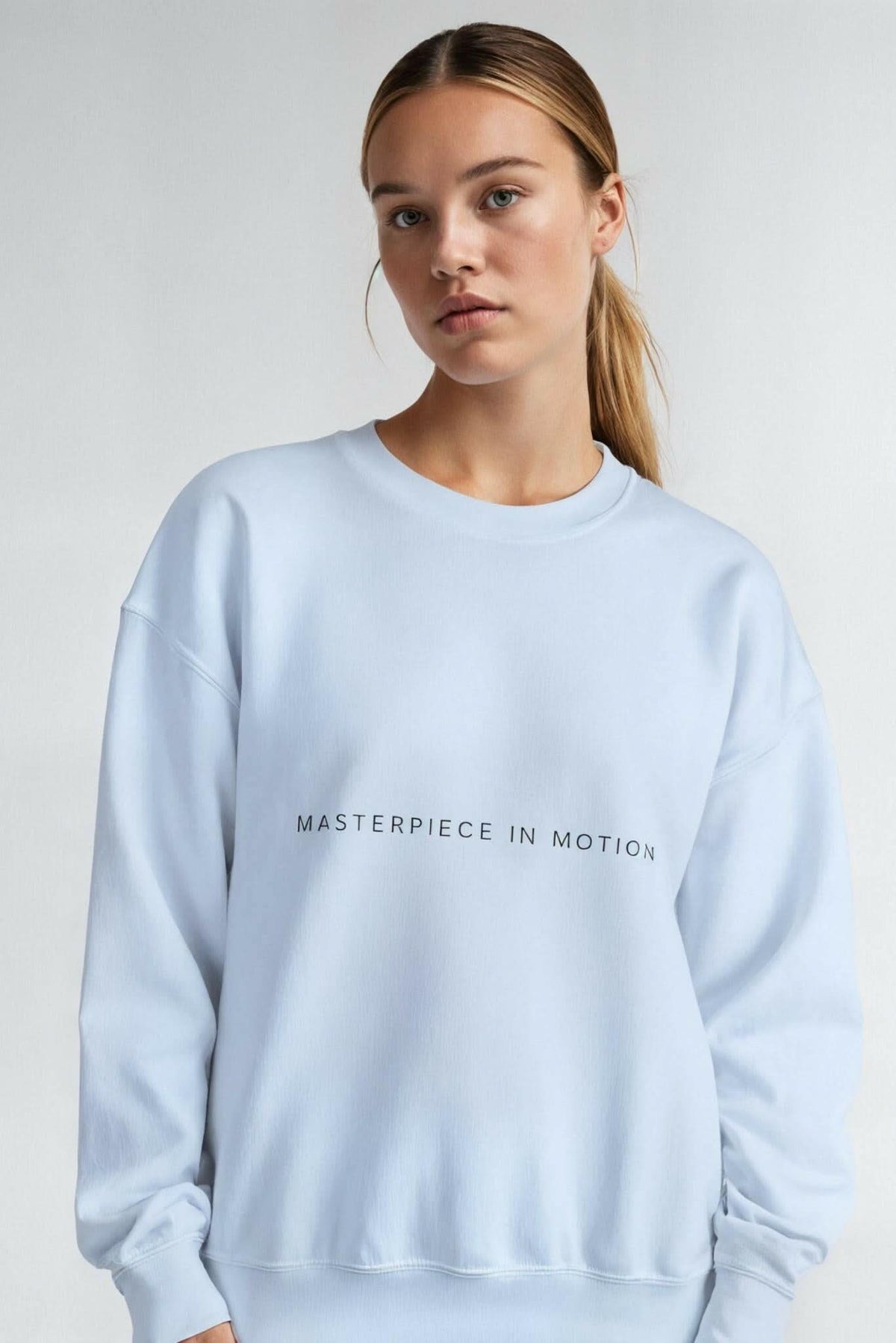 Light blue crewneck sweatshirt with 'MASTERPIECE IN MOTION' chest print