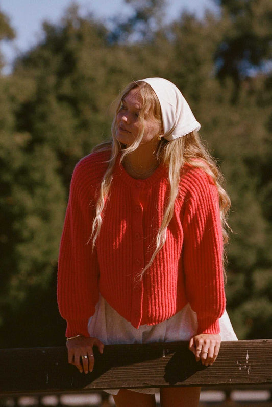 Bright red knit cardigan sweater with button front and ribbed cuffs, long sleeves.