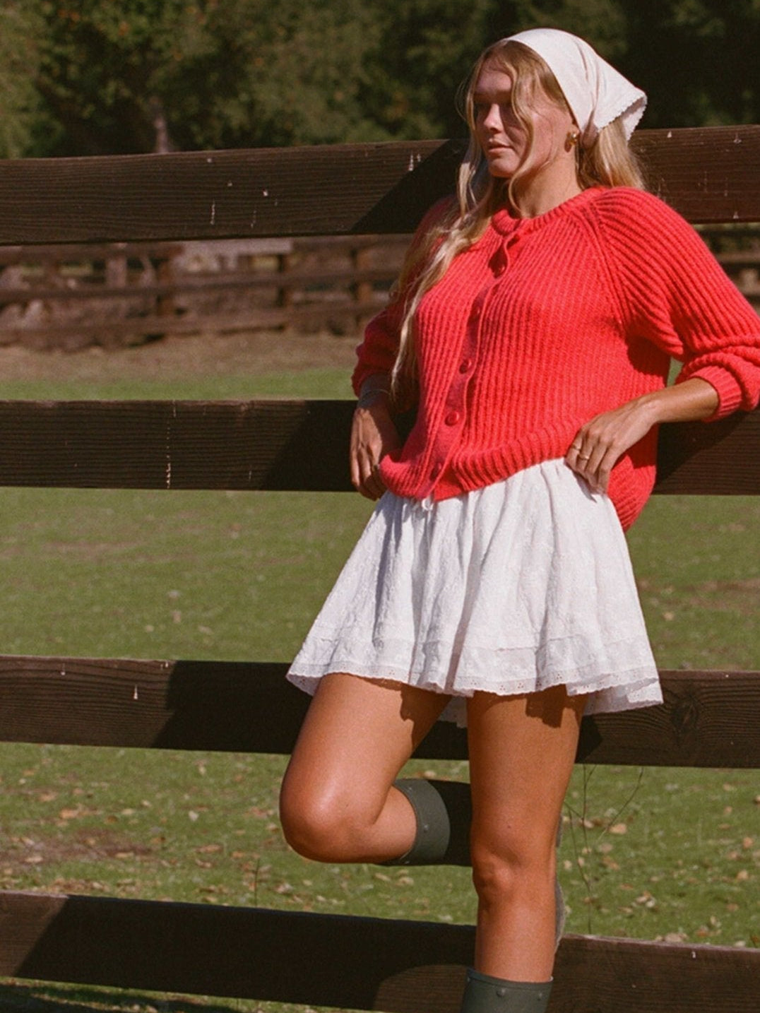 Bright red button-front knit cardigan sweater with ribbed cuffs and long sleeves.