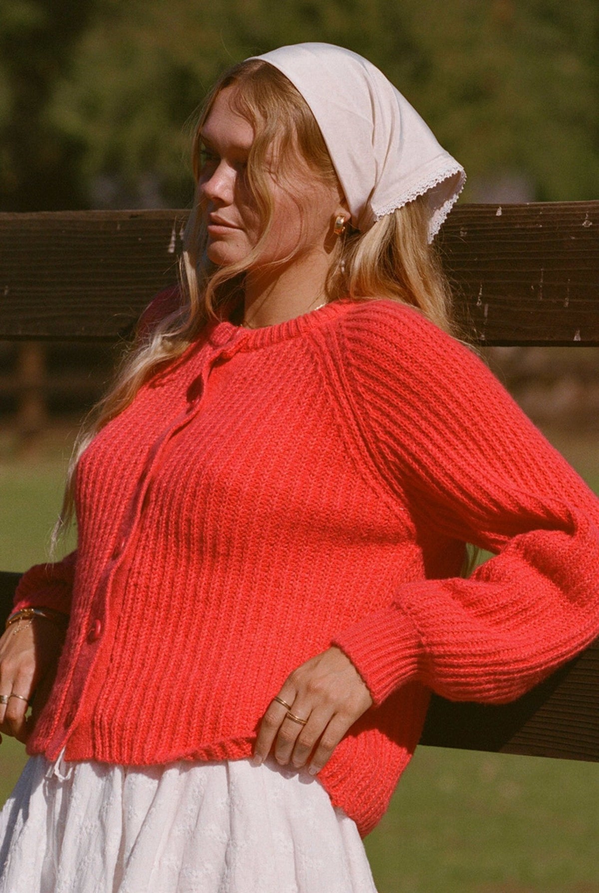 Bright red textured knit cardigan sweater with button front and ribbed cuffs, long sleeves.