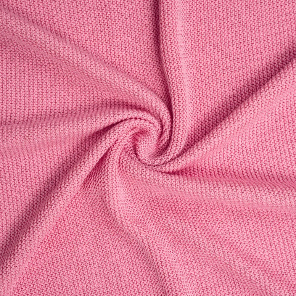 Close-up of rose pink knit fabric with soft braided yarn texture