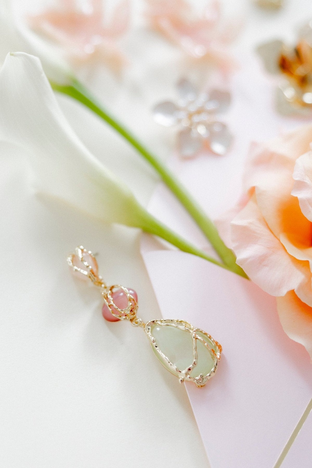 Single gold-tone drop earring with pink and green teardrop charm and crystal accents
