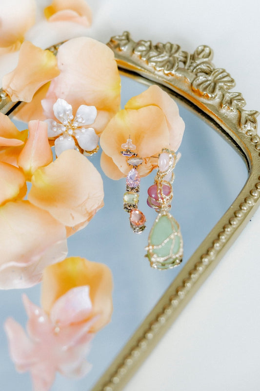 Dangling statement earrings with pink oval beads and green pear-shaped charm, gold-tone
