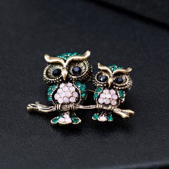 Rhinestone owl brooch close-up of two owls with green crystals and pink bodies