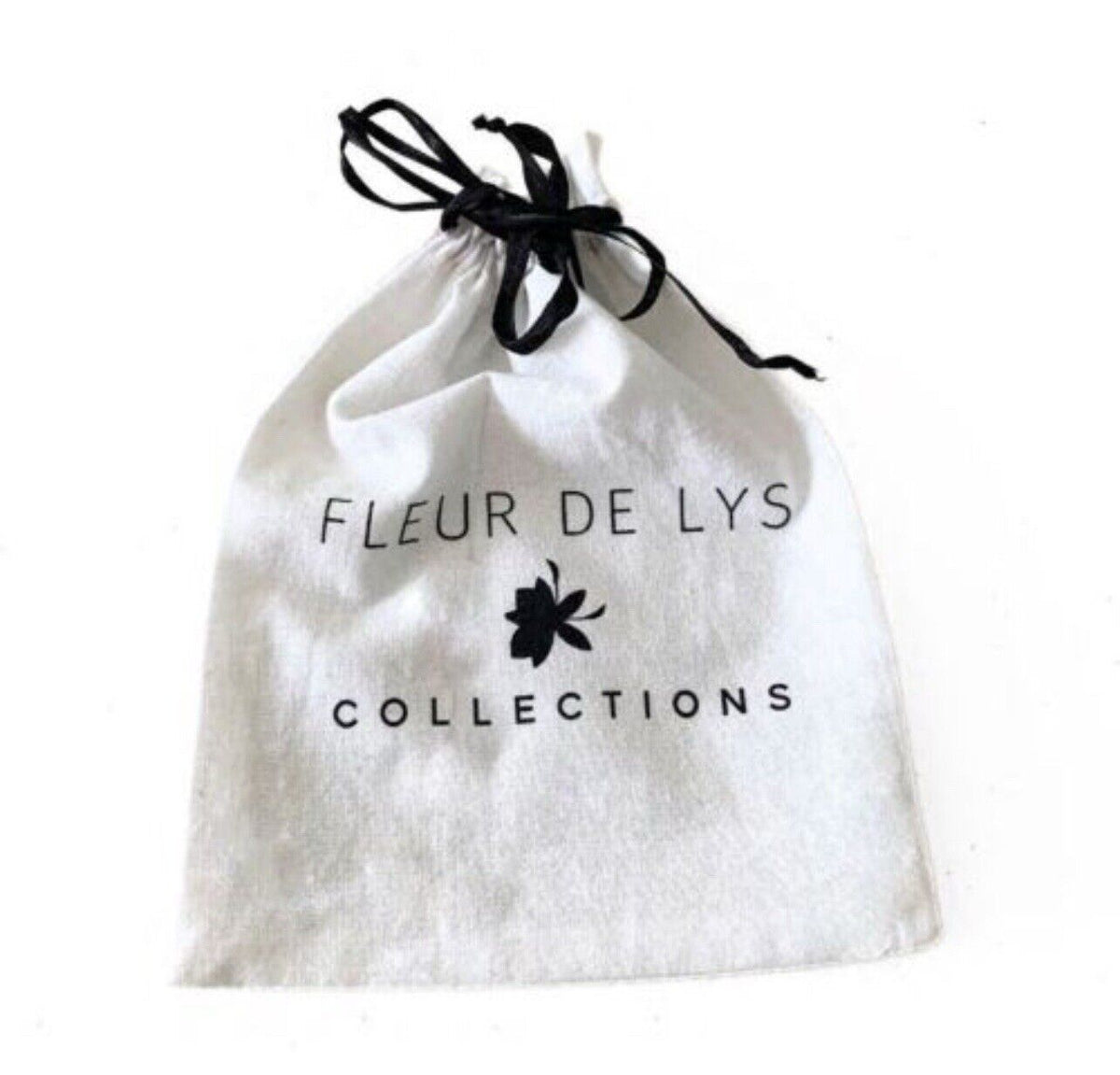 White drawstring pouch with black text "FLEUR DE LYS COLLECTIONS"