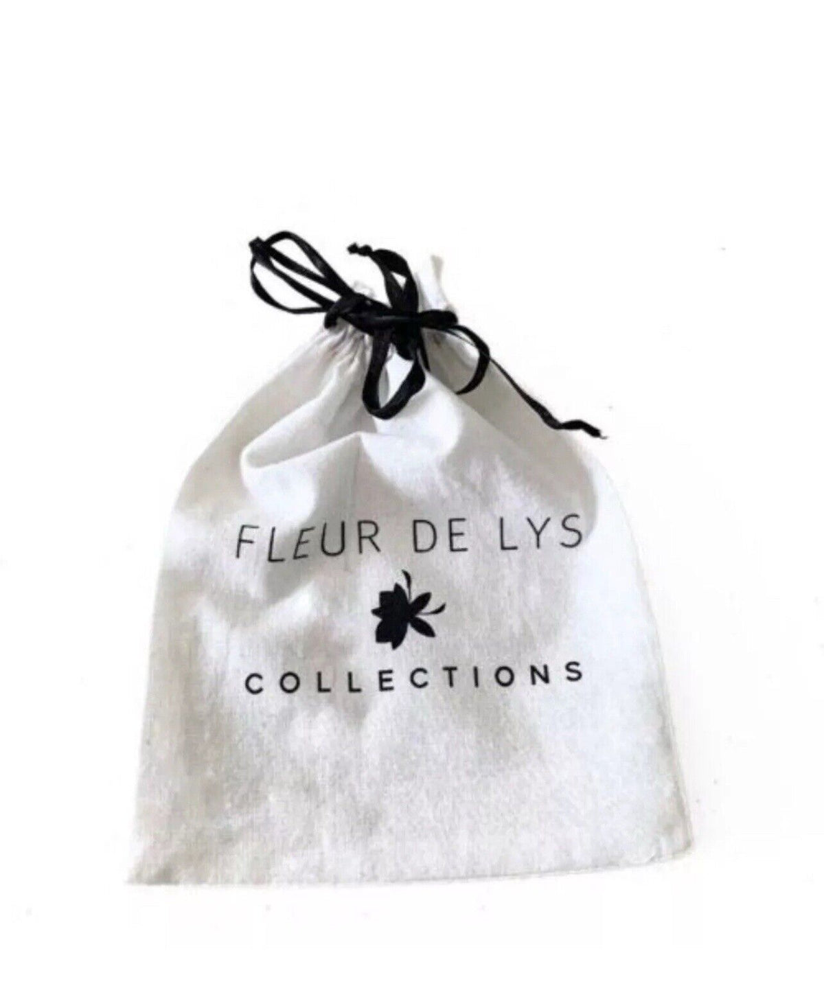 White drawstring pouch with black bow and text 'FLEUR DE LYS COLLECTIONS'