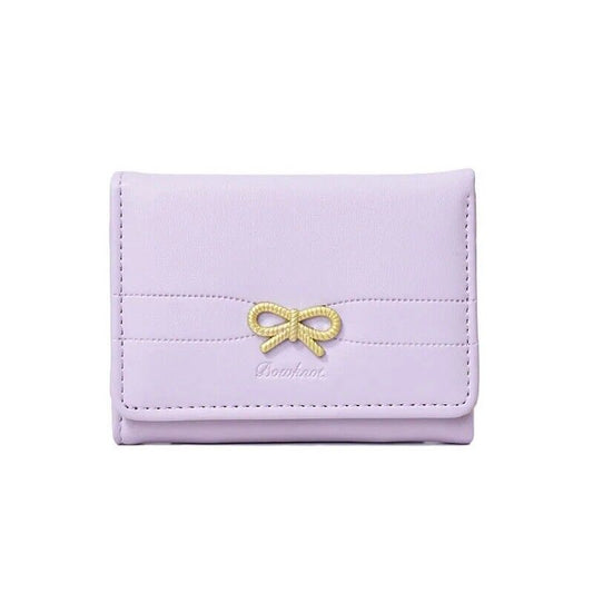 Lavender card holder wallet with gold bow emblem, stitched front