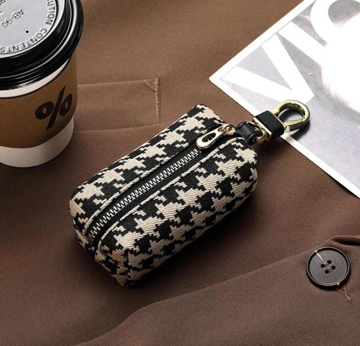 Black-and-white houndstooth mini zip wallet keychain with keyring, angled view