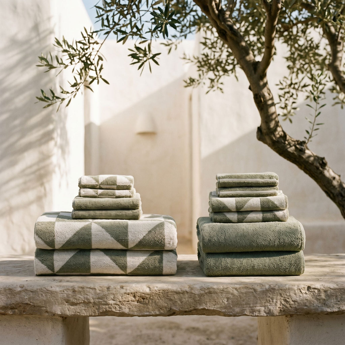 Sage green and ecru cotton towels stacked with a geometric pattern