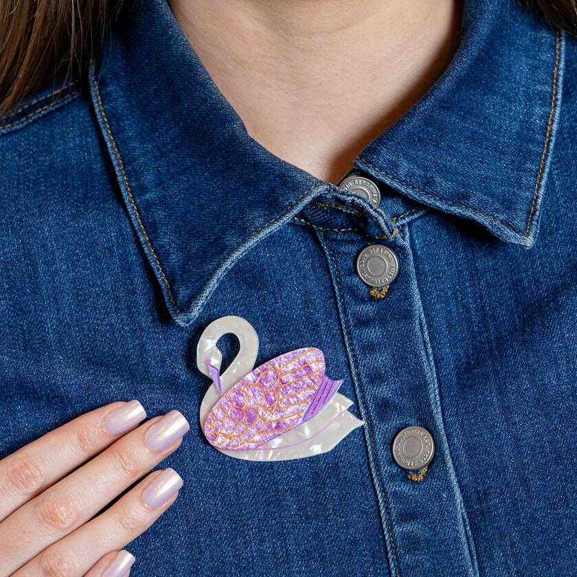 Purple swan enamel brooch with silver pin on blue denim jacket collar