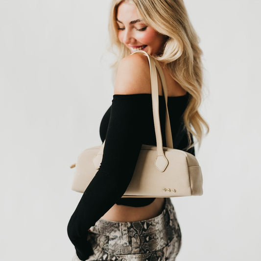 Light suede barrel shoulder bag with long strap and small metal studs