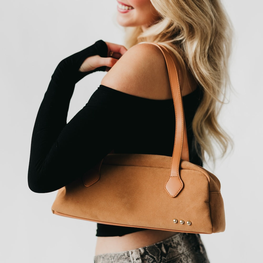 Camel suede barrel shoulder bag with long strap and metal studs on front