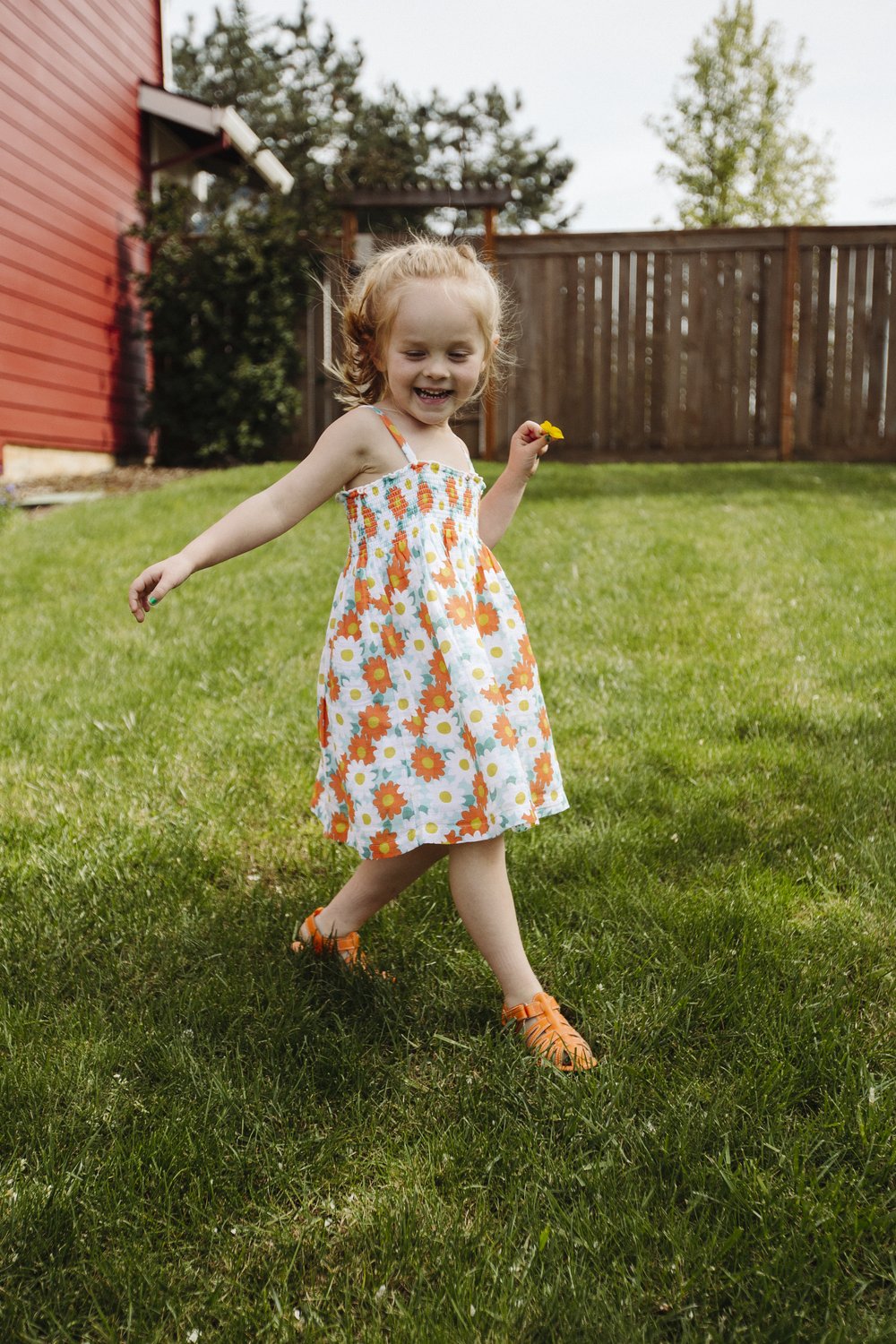 Orange barefoot sandals on child’s feet, open-toe cutouts and adjustable straps