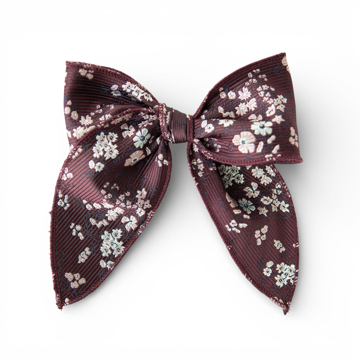 Floral hair bow in dark sangria with small white blossoms and layered bow loops