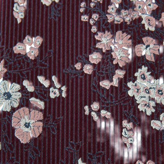 Close-up of youth necktie fabric: burgundy pinstripes with white floral motifs