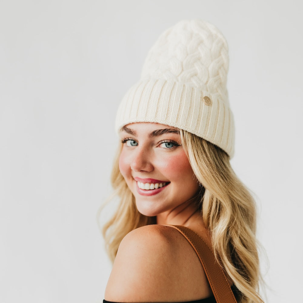 Cream cashmere beanie with satin-lined cuff, rib knit brim, and cable crown