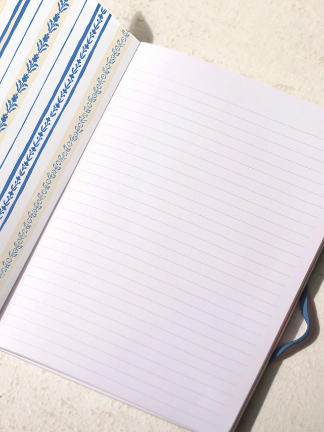 Lined notebook pages with blue illustrated cover border, open view