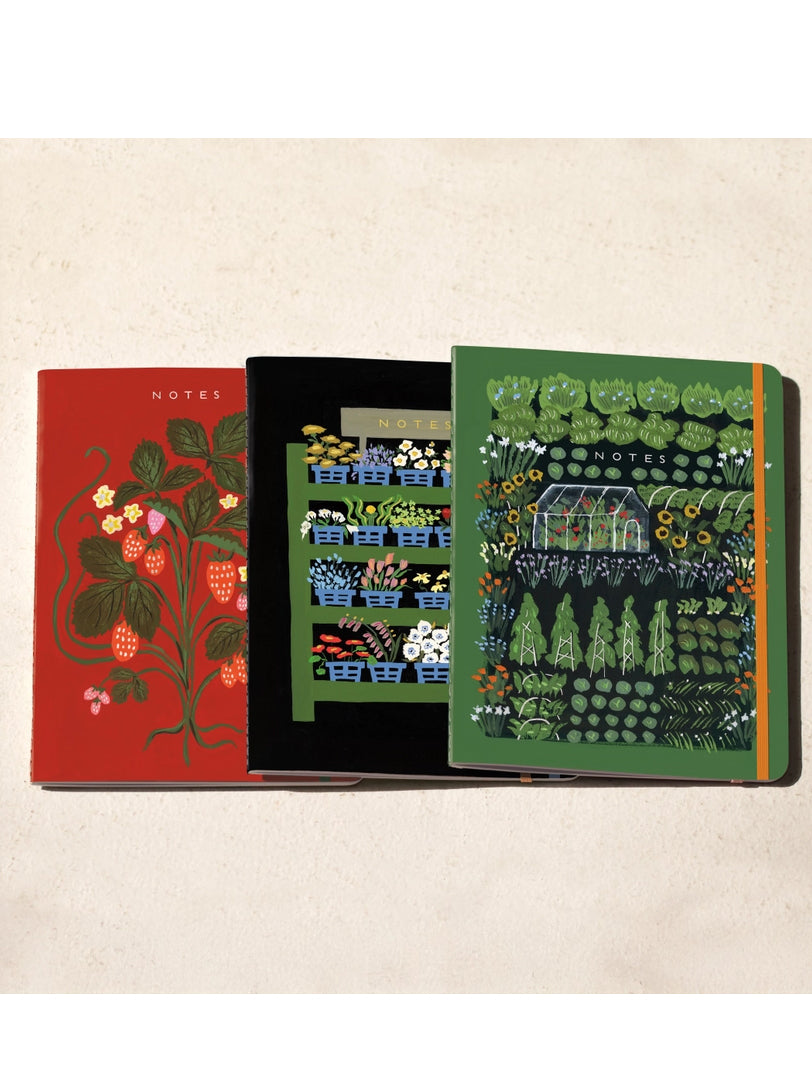 Three sewn notebooks with botanical cover art in red, dark, and green.
