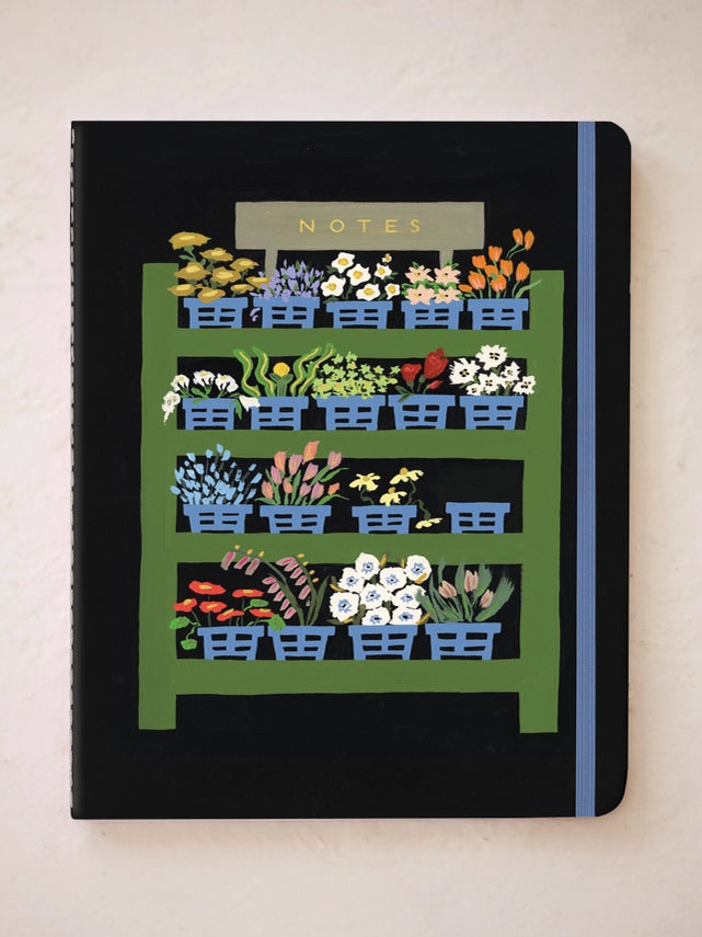 Dark NOTES notebook with illustrated greenhouse row houses and colorful plants.