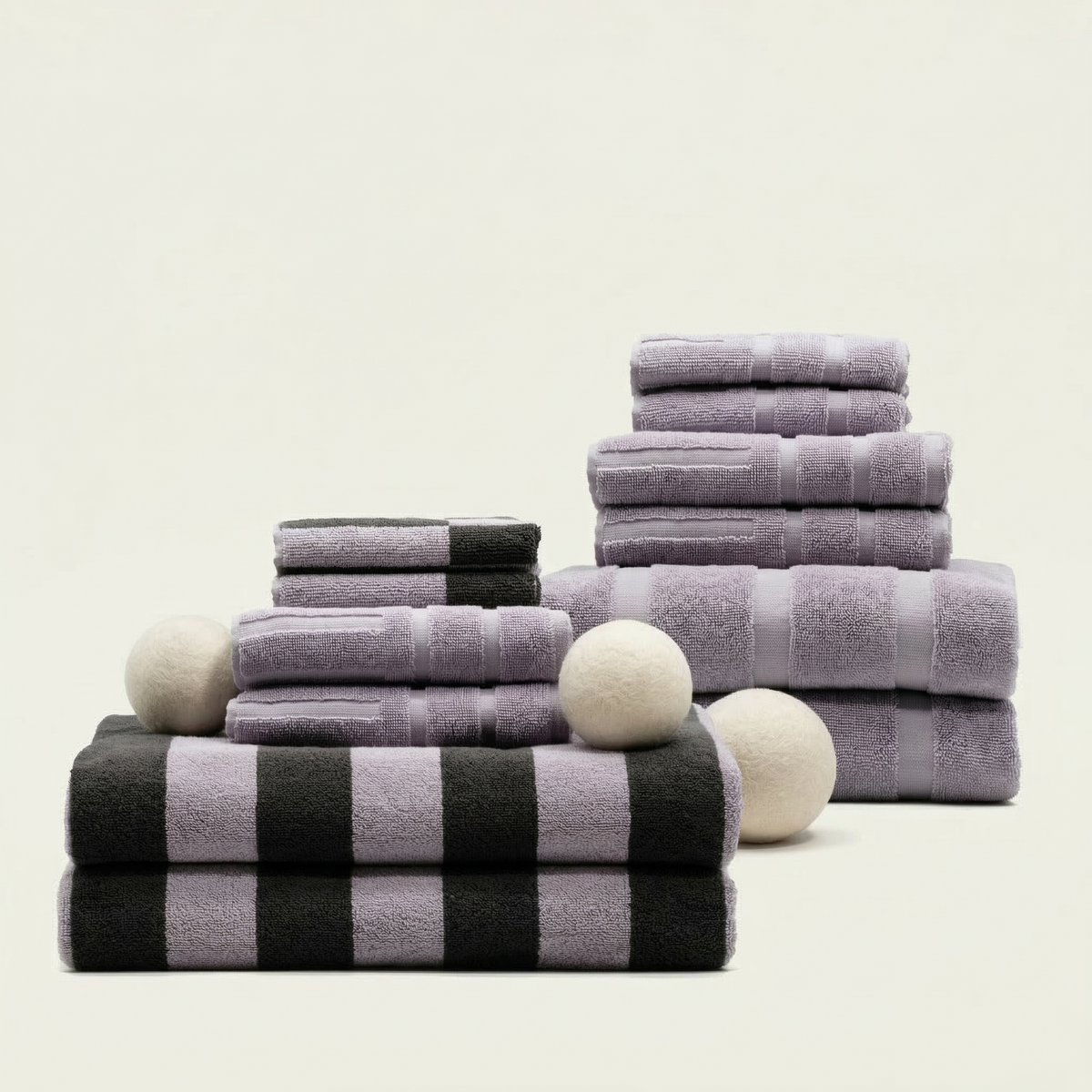 Stacked lilac and charcoal towels with black-and-white plaid accents