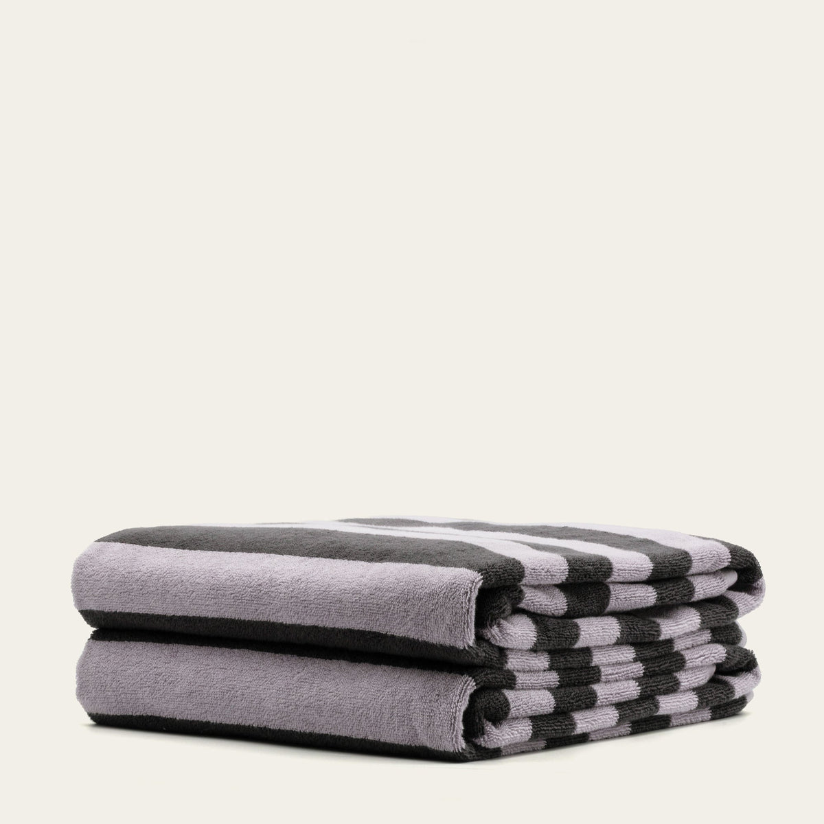 Stack of light lilac towels with matching dark and white striped edge