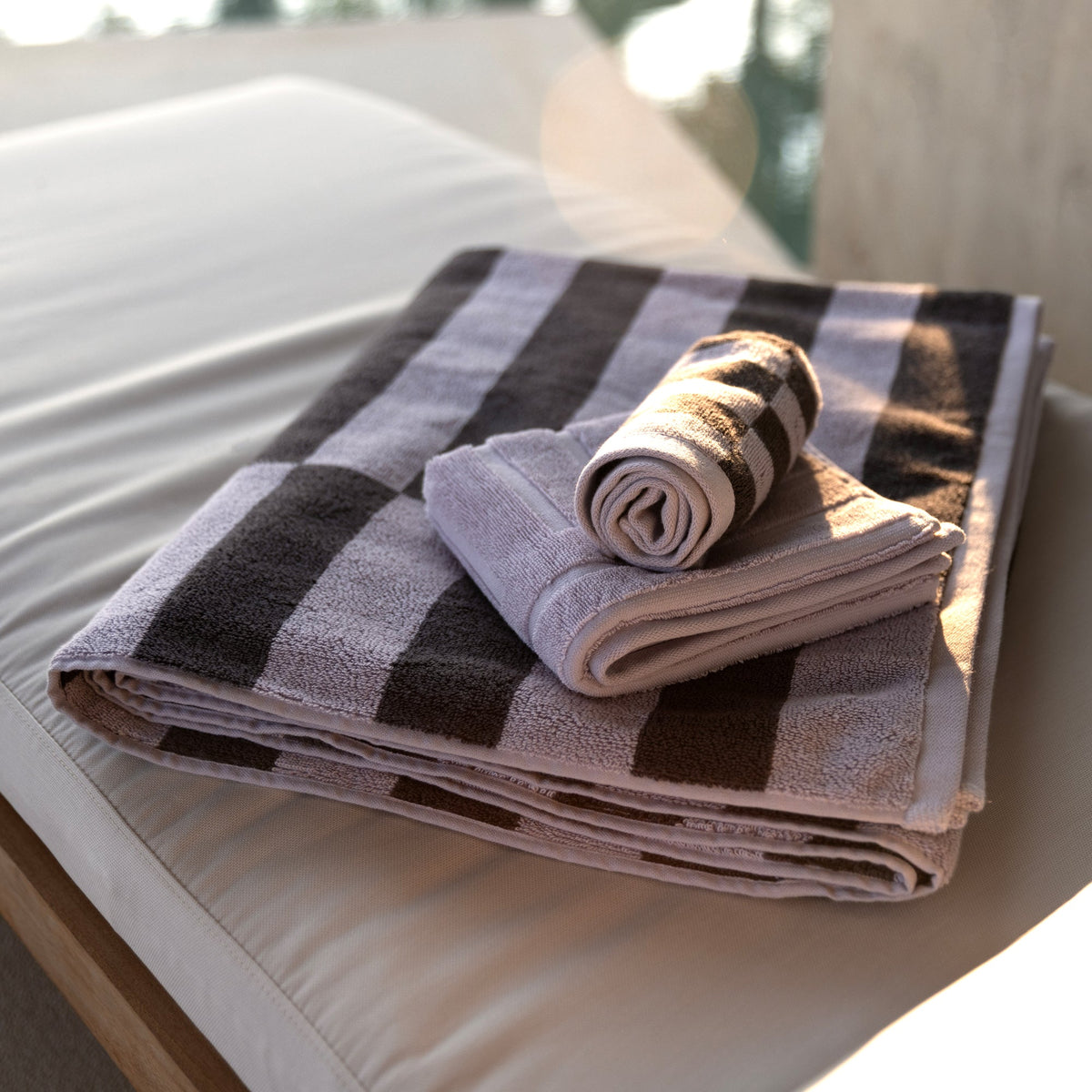 Folded cotton towels with gray and charcoal checkered stripe pattern