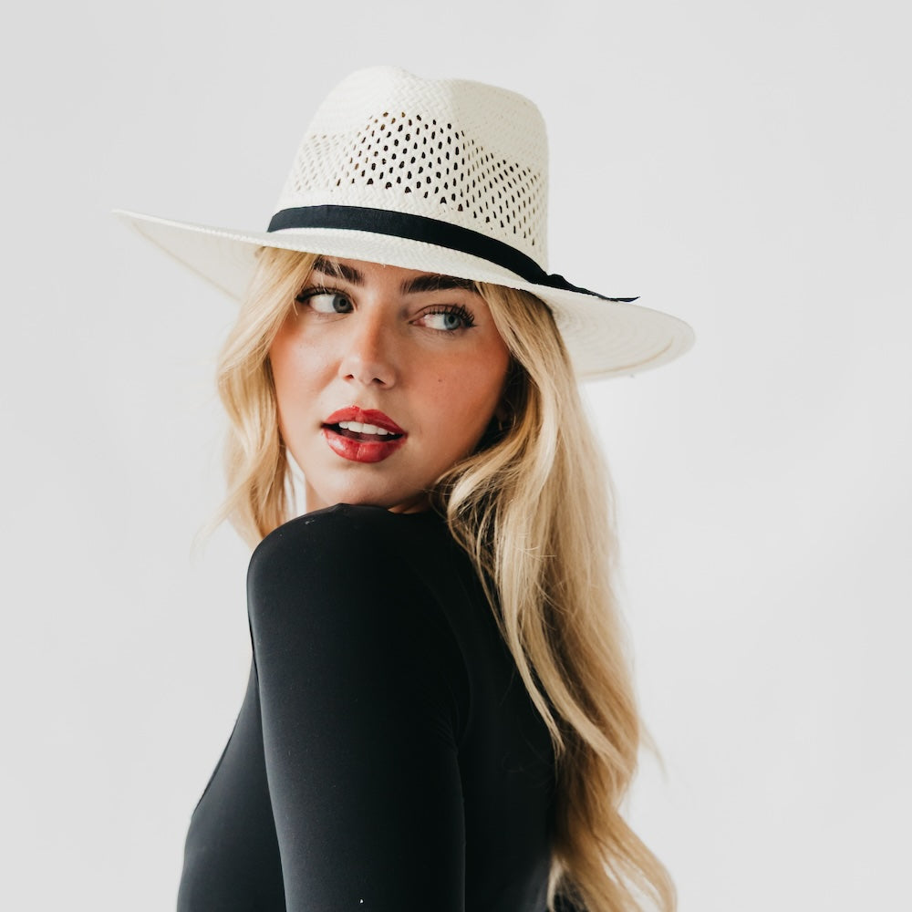 White perforated western sun hat with black band, wide brim, side view.