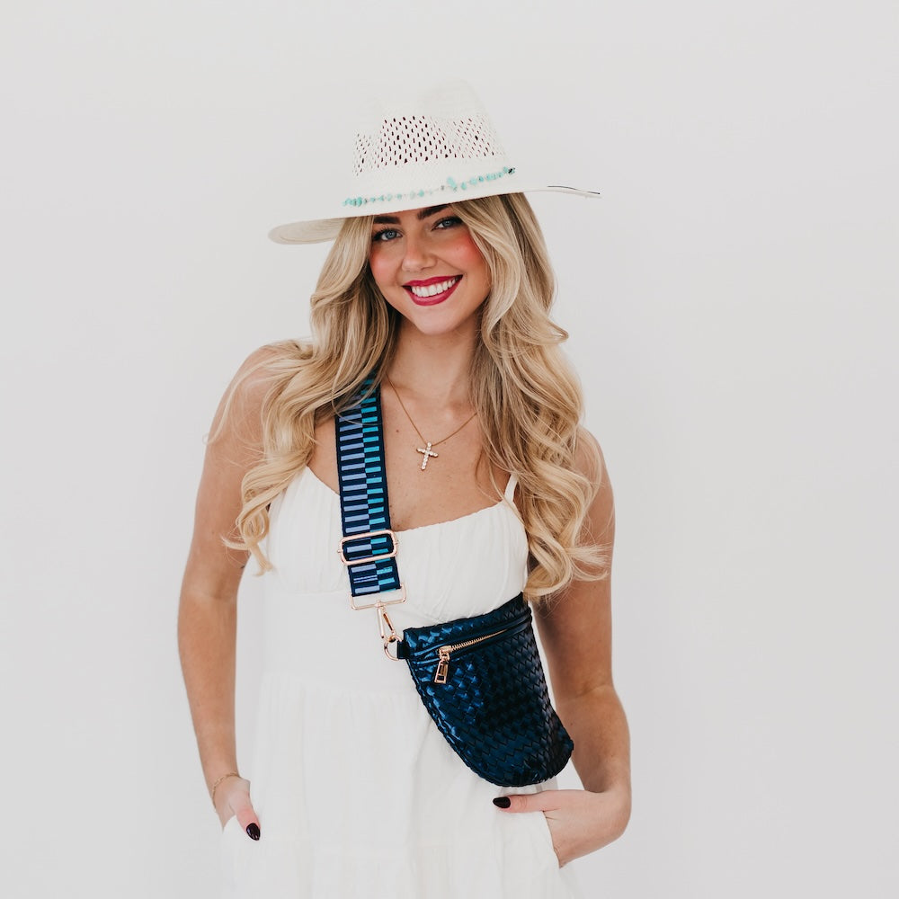 White perforated western sun hat with turquoise beaded trim, wide brim, angled view.