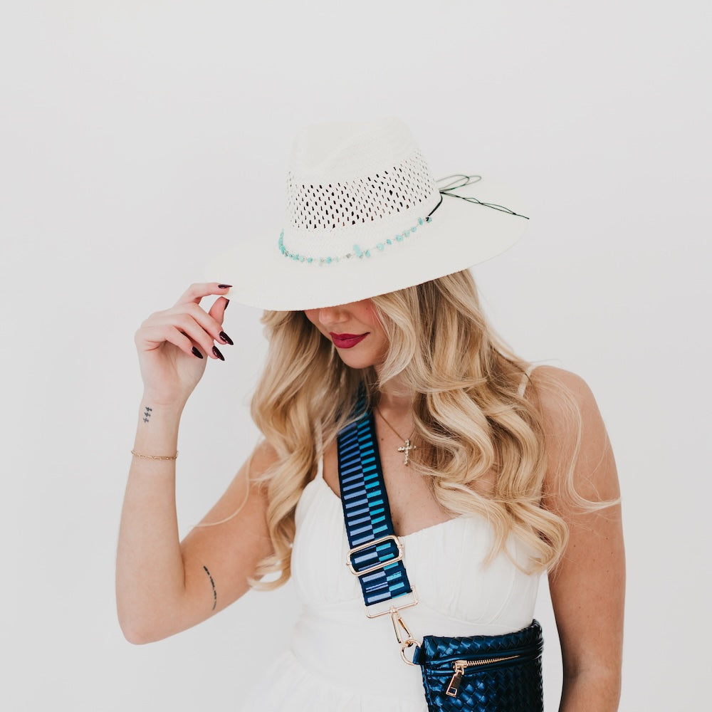 White perforated western sun hat with turquoise beaded band and tie, wide brim.