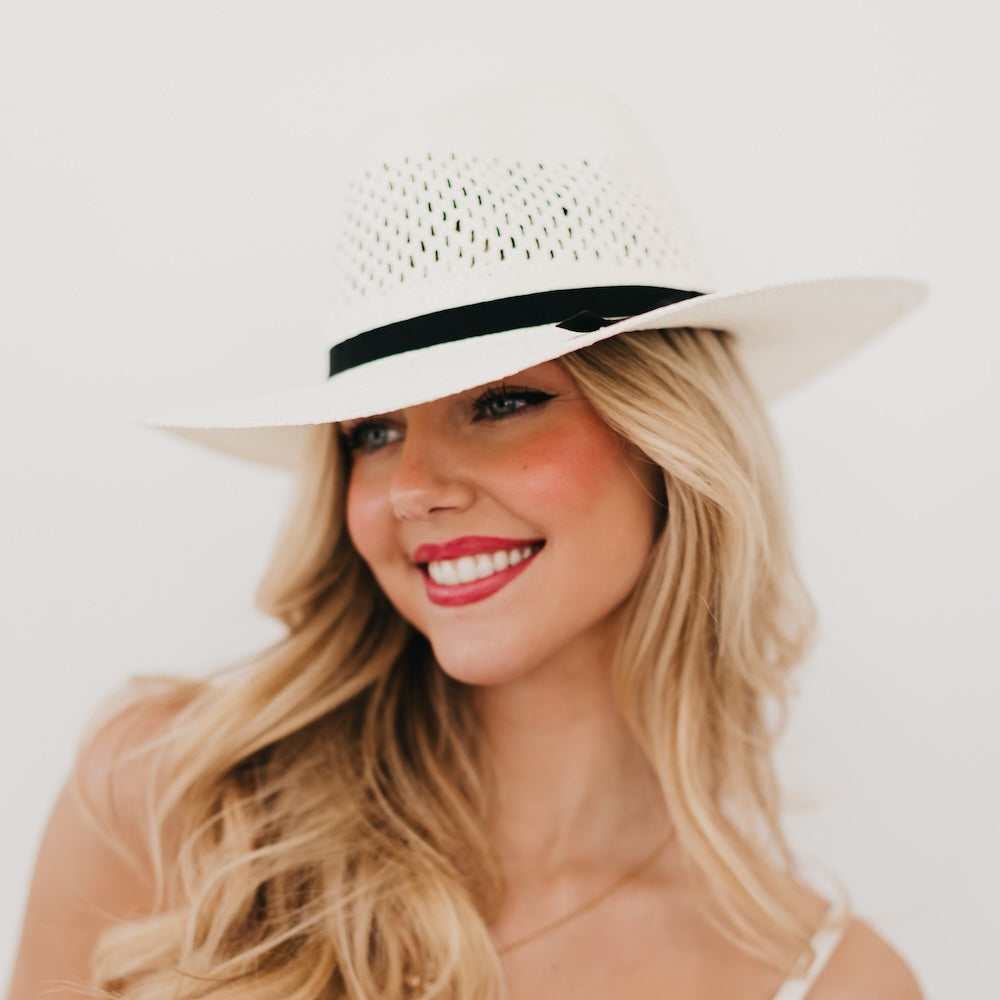 White perforated western sun hat with black band, wide brim, front view.