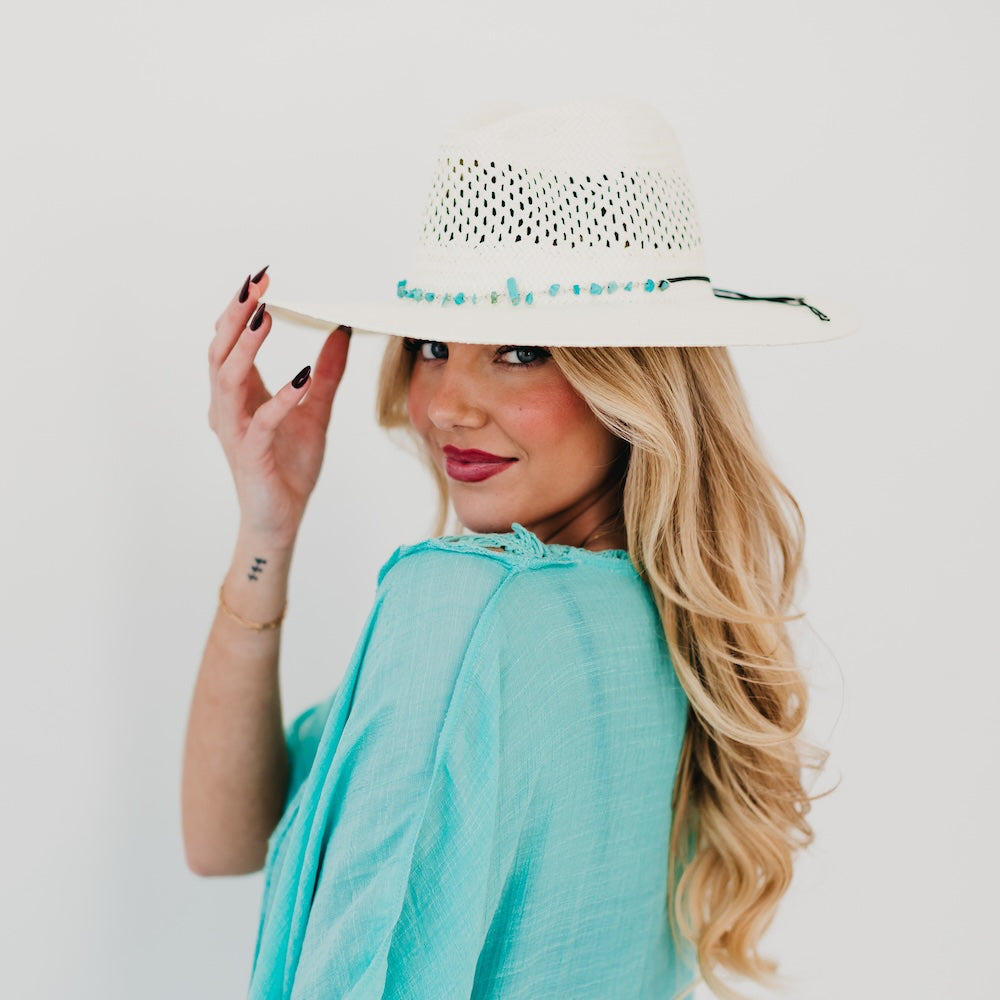 White perforated western sun hat with turquoise beaded band and tie, wide brim.