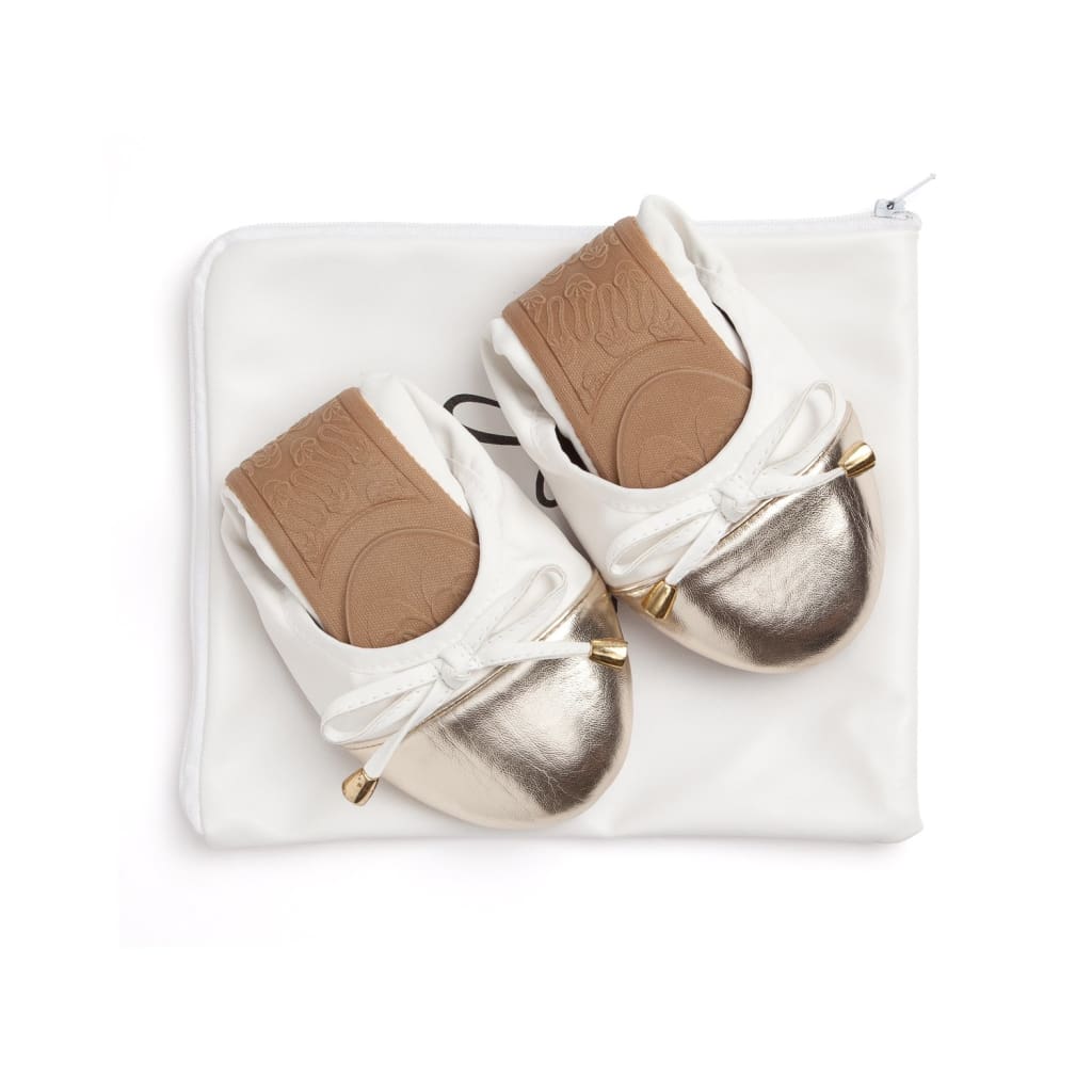 Two white flats with metallic toe caps, bow laces, packed in white pouch