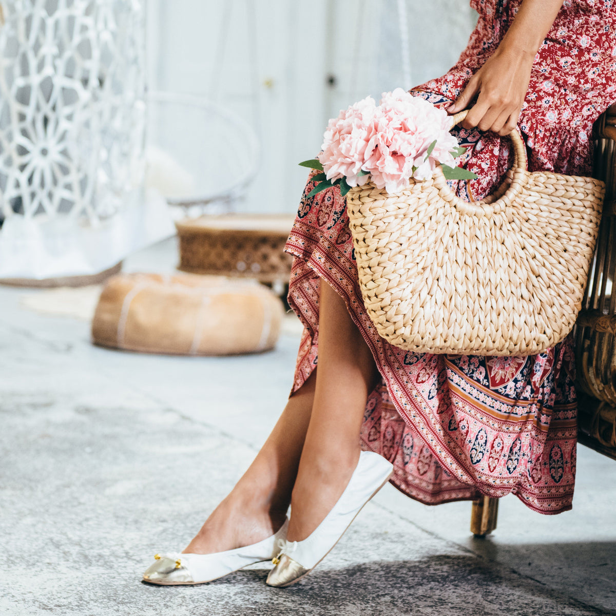 White flats with metallic toe worn by person, gold bow and low sole